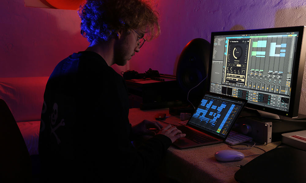 Setup moderno de producción musical con Ableton Live como DAW principal en un estudio urbano