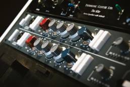 Productor aplicando ecualización a kicks, snares y melodías para mejorar la mezcla del beat