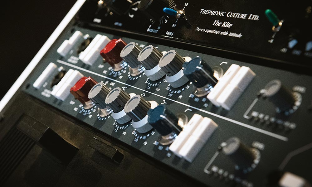 Productor aplicando ecualización a kicks, snares y melodías para mejorar la mezcla del beat